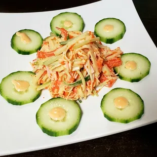 a plate of salad with cucumbers