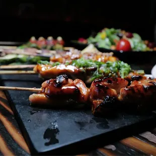 skewered food on a black plate