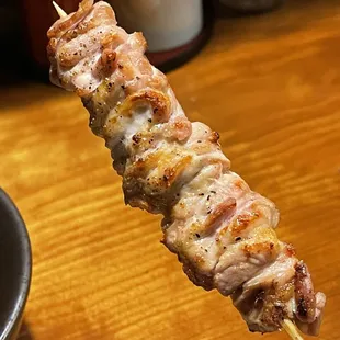 a hand holding a skewer