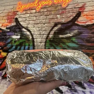 a hand holding a sandwich