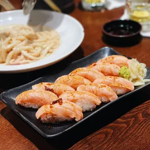 a plate of sushi and a bowl of noodles