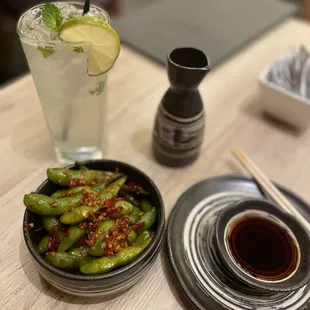 a bowl of green beans and a glass of water