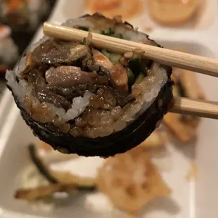 a sushi roll with chopsticks