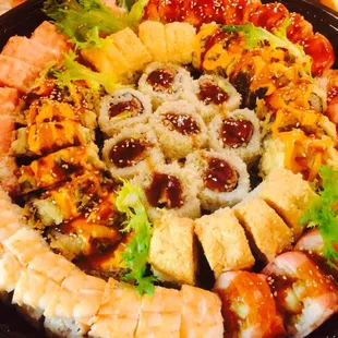 a platter of sushi and vegetables