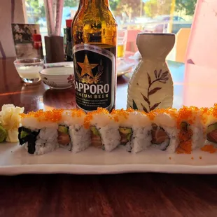 a bottle of beer and a plate of sushi