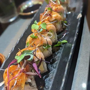 a plate of sushi with a variety of toppings