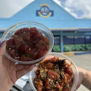 a hand holding two bowls of food