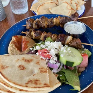 Lamb kebabs, Greek salad, hummus, and pita