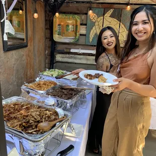 two women holding plates of food
