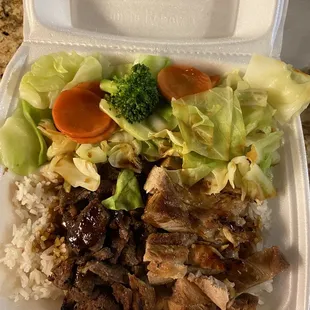 a take out container with meat, rice, and vegetables