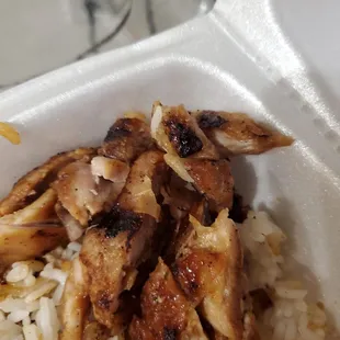 a chicken and rice dish in a styrofoam container