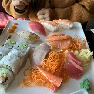 a plate of sushi and rolls