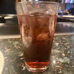 a glass of iced tea on a counter