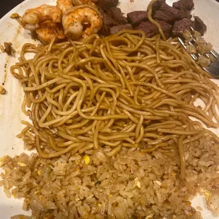 a plate of noodles, meat, and vegetables