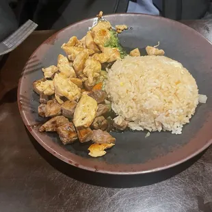 Steak and chicken with fried rice and vegetables.