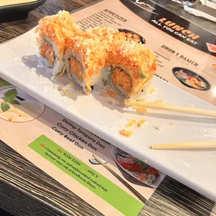 a plate of sushi with chopsticks