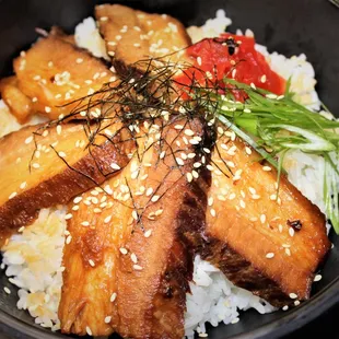 Chashu Don is made up of roast pork belly, pickled radish and scallion over rice drizzled with sweet dashi sauce