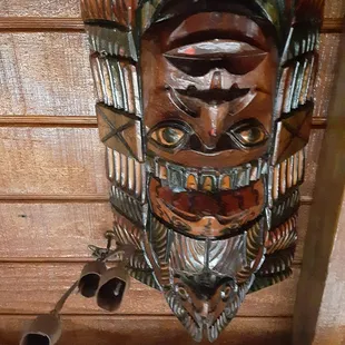 a wooden mask hanging from the ceiling