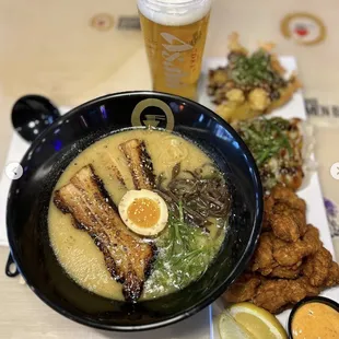 a bowl of ramen and a glass of beer