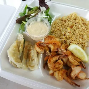 shrimp, rice, and salad in a styrofoam container