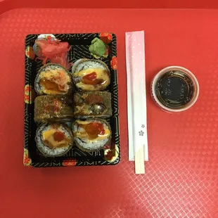 a tray of sushi and a bowl of soy sauce