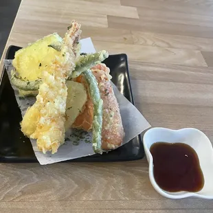 a plate of food and a small bowl of sauce