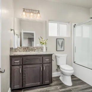 a bathroom with a shower, toilet, and sink