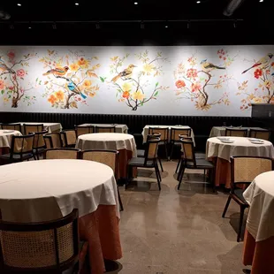 Inside restaurant with beautiful hand painted wall of birds. 15 tables for 4.