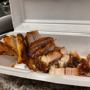 a take out container with meat in it