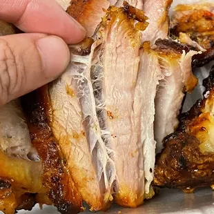 a person grabbing a piece of meat