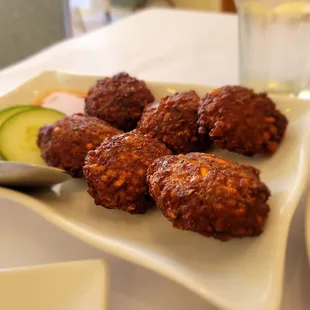 a plate of meatballs and a glass of water