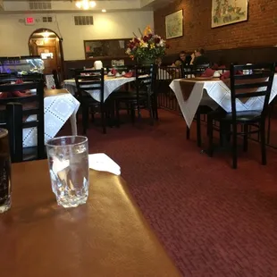 a restaurant with tables and chairs and a glass of water on the table