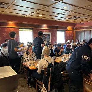 a large group of people sitting at tables in a restaurant