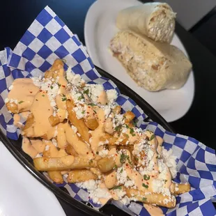 a plate of french fries and a plate of burritos