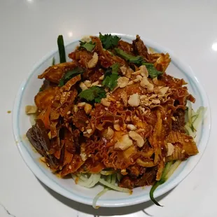 a bowl of noodles with meat and vegetables