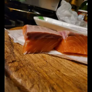 two pieces of salmon on a cutting board