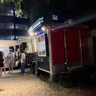 a group of people standing in front of a food truck