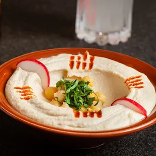 a bowl of hummus and radishes