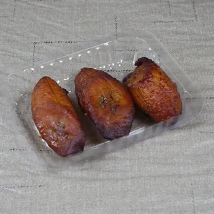 three fried bananas in a plastic container