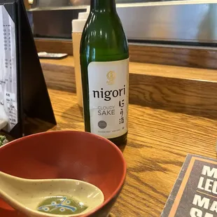 a bottle of nigris sake and a bowl of miso sauce