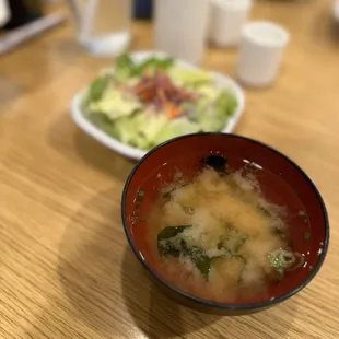 a bowl of soup and a plate of salad