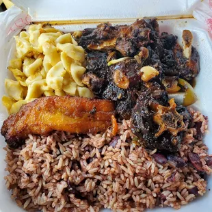 Oxtails with rice and peas with mac and cheese and plantains