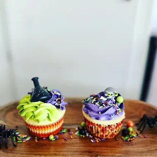 two halloween cupcakes on a wooden plate
