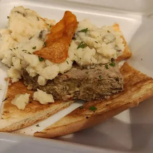 meat and mashed potatoes in a styrofoam container