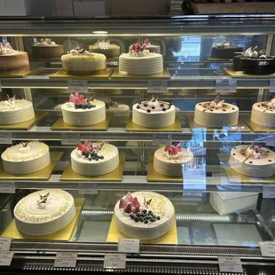 a variety of cakes in a display case