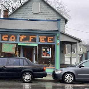 two cars parked in front of a coffee shop