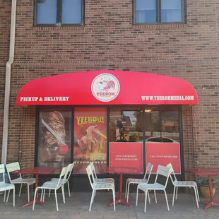 a restaurant with a red awning