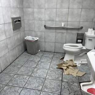 a bathroom with a toilet and a trash can