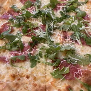 a pizza topped with greens