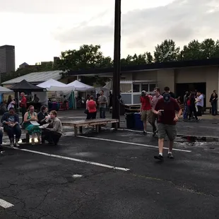 a group of people sitting on benches in a parking lot